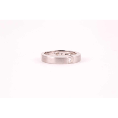 26 - An 18ct white gold and diamond ring, the matte-finished mount inset with a princess-cut diamond of a... 