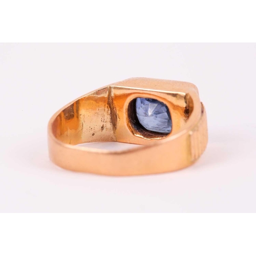 27 - A yellow metal and sapphire ring, set east to west with a mixed rectangular-cut sapphire, the stone ... 