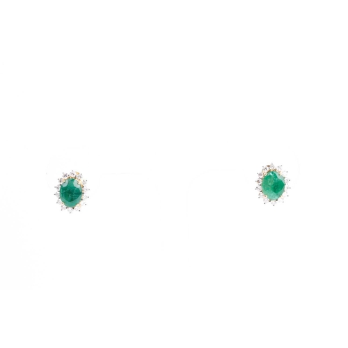 33 - A pair of emerald and diamond cluster earrings, the mixed oval-cut emerald in four claw mount above ... 