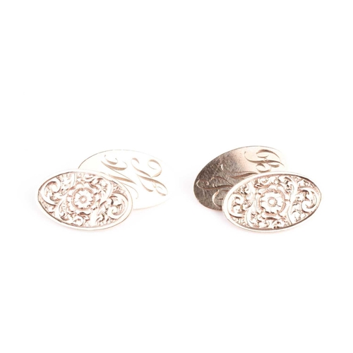 49 - A pair of 9ct yellow gold cufflinks, with oval plaques, one with floral engraved decoration, the oth... 