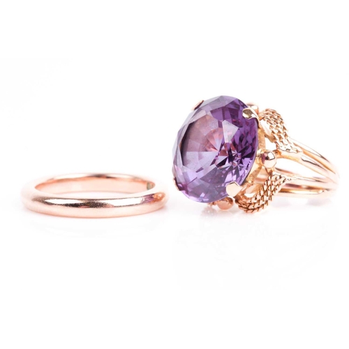 50 - A yellow metal and synthetic corundum ring, set with a mixed round-cut stone with Alexandrite colour... 