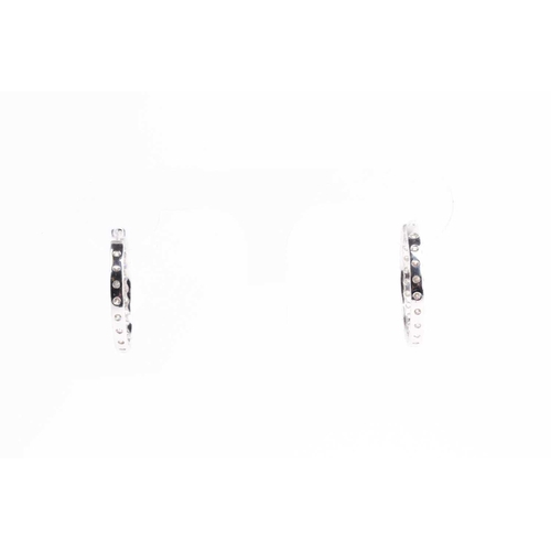 54 - A fine pair of diamond earrings, each set with round brilliant-cut diamonds to the front of the hoop... 