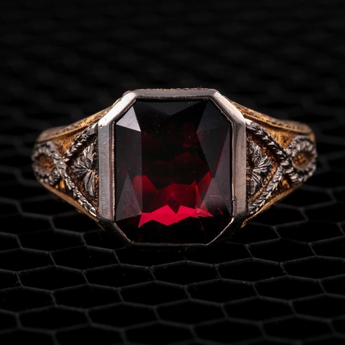 59 - A gentleman's yellow gold and garnet ring, set with a mixed rectangular-cut garnet, measuring approx... 