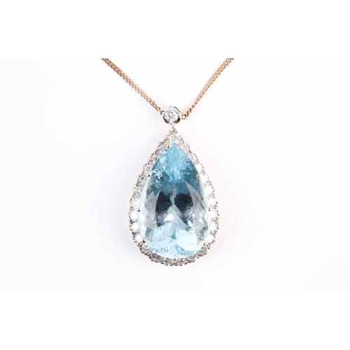 61 - A diamond and aquamarine cluster pendant, the pear cut aquamarine within a border of brilliant cut d... 