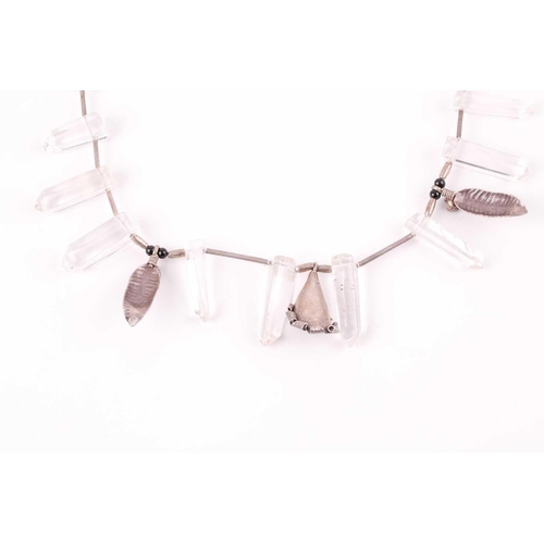 67 - A silver and rock crystal necklace, comprised of smoothly polished quarzt crystals, with three flora... 