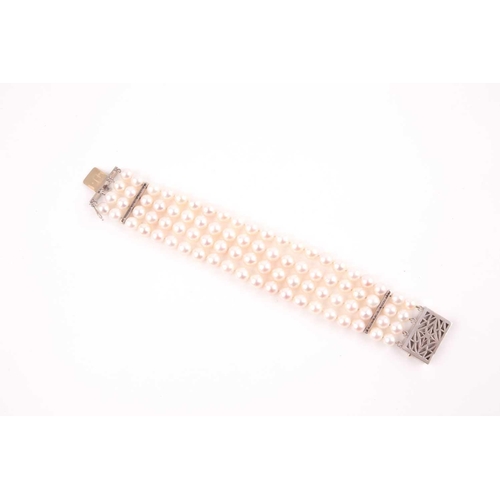 72 - A diamond and pearl bracelet, comprised of four rows of round cultured white pearls, approximately 7... 