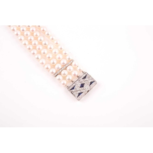 72 - A diamond and pearl bracelet, comprised of four rows of round cultured white pearls, approximately 7... 