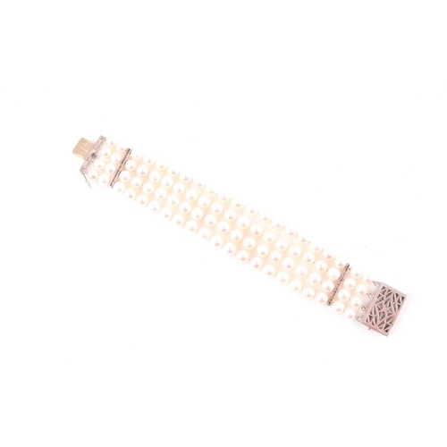 72 - A diamond and pearl bracelet, comprised of four rows of round cultured white pearls, approximately 7... 