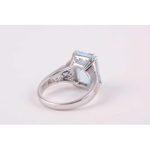 74 - An aquamarine, diamond and sapphire cocktail ring, the baguette cut aquamarine weighing approximatel... 