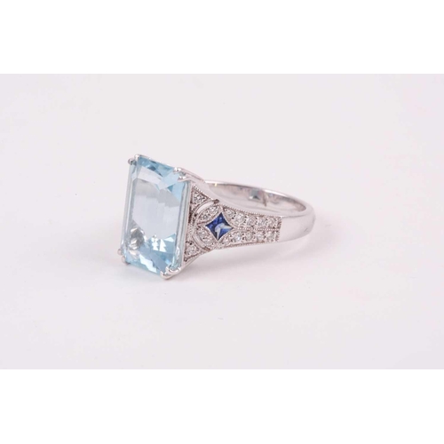 74 - An aquamarine, diamond and sapphire cocktail ring, the baguette cut aquamarine weighing approximatel... 