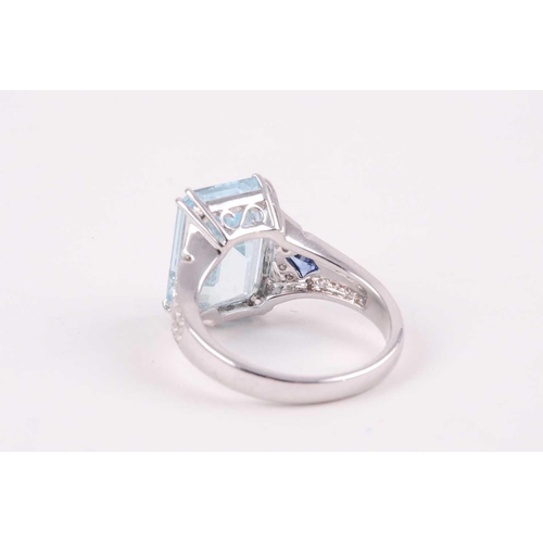 74 - An aquamarine, diamond and sapphire cocktail ring, the baguette cut aquamarine weighing approximatel... 