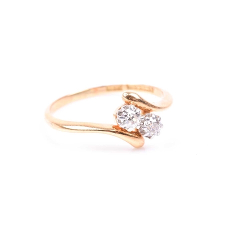 81 - An 18ct yellow gold and diamond crossover ring, set with two old round-cut diamonds of approximately... 