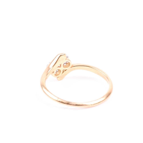 81 - An 18ct yellow gold and diamond crossover ring, set with two old round-cut diamonds of approximately... 