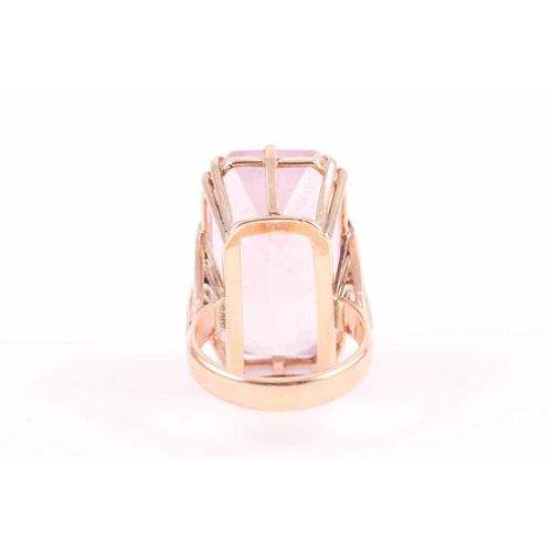 82 - A yellow metal and pink quartz ring, set with a rectangular-cut stone, in a yellow metal basket moun... 