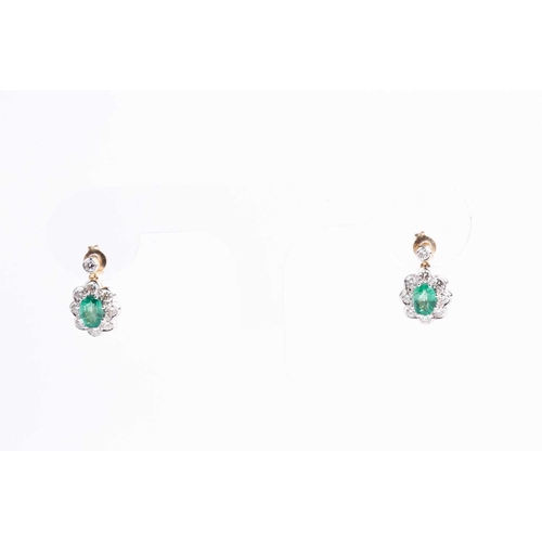 86 - A pair of diamond and emerald cluster drop earrings, each set with a mixed oval-cut emerald within a... 