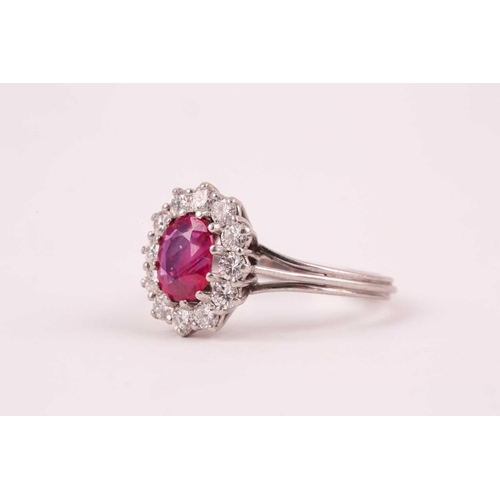 9 - A ruby and diamond cluster ring, the oval mixed-cut ruby, approximately 1ct, surrounded by twelve br... 