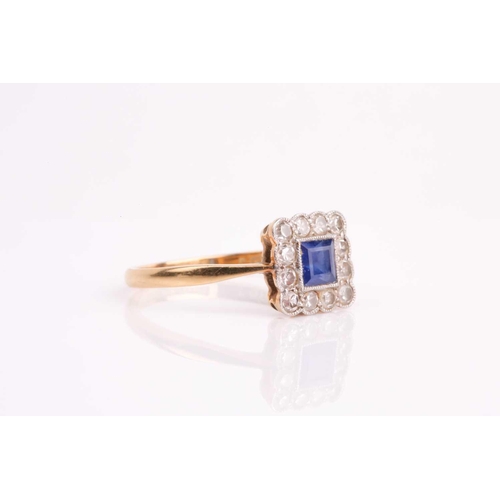 90 - An early 20th century sapphire and diamond cluster ring, the calibre cut sapphire in millegrain moun... 