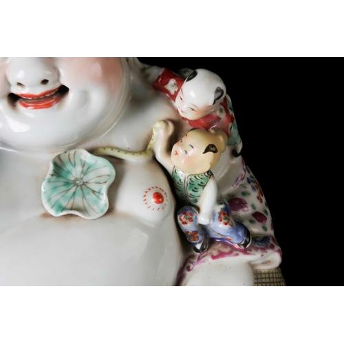 85A - A Chinese 20th century Famille rose, porcelain figure of the corpulent, seated Hotei with red-brick ... 