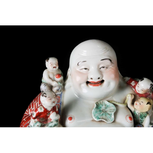 85A - A Chinese 20th century Famille rose, porcelain figure of the corpulent, seated Hotei with red-brick ... 