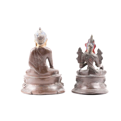 87 - A Tibetan patinated bronze figure of a Buddha seated on a double lotus socle with hands in the bhumi... 