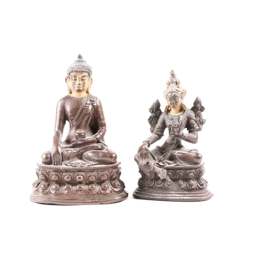 87 - A Tibetan patinated bronze figure of a Buddha seated on a double lotus socle with hands in the bhumi... 