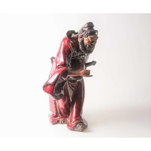 105 - A Shiwan flambe glaze figure of Guandi, mid 20th century, a fierce expression upon his face, modelle... 