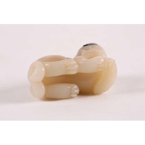 127 - A Chinese, carved off-white and grey jade, Tang-style crouching lion. 81 grams 5 cm long x 3.8 cm hi... 