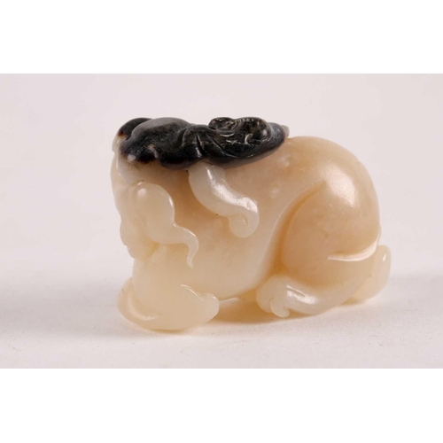 127 - A Chinese, carved off-white and grey jade, Tang-style crouching lion. 81 grams 5 cm long x 3.8 cm hi... 