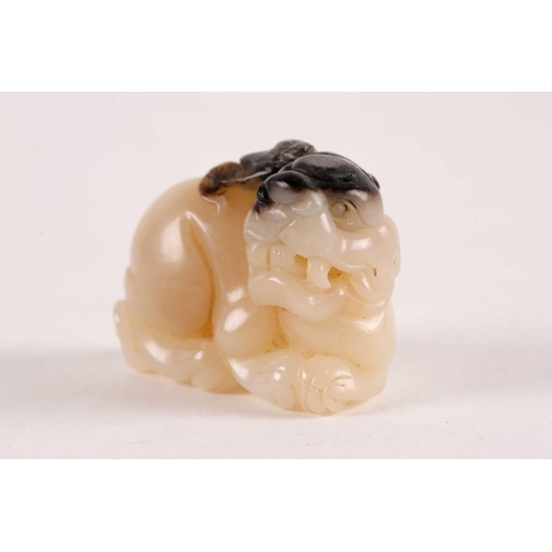 127 - A Chinese, carved off-white and grey jade, Tang-style crouching lion. 81 grams 5 cm long x 3.8 cm hi... 