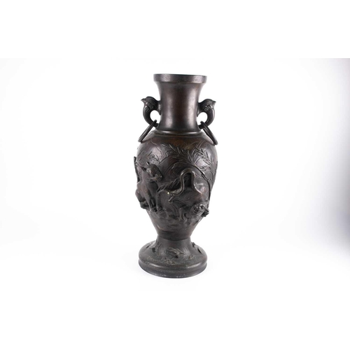 139 - A large bronze Japanese ring-handled vase, with relief decoration depicting lions amongst foliage, a... 