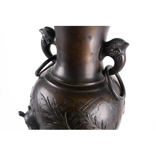 139 - A large bronze Japanese ring-handled vase, with relief decoration depicting lions amongst foliage, a... 