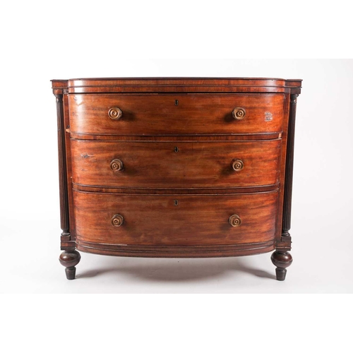 209 - A Regency figured mahogany break bow-fronted commode chest of three long drawers. The drawers flanke... 