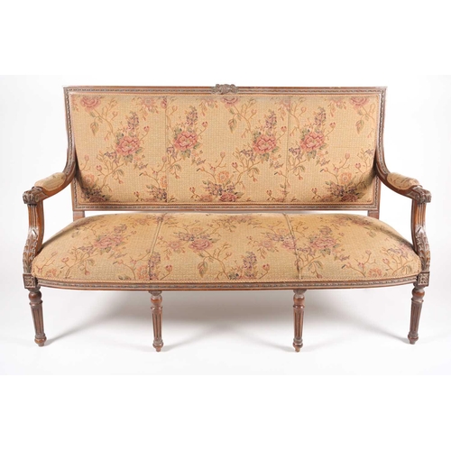 220 - An early 20th century, French Louis XVI style carved beechwood three seat sofa. With floral stuff ov... 