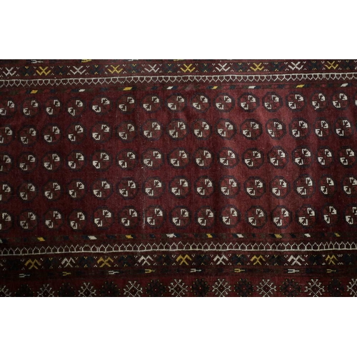 228 - A 20th century Turkomen rug with a lattice of guls on a madder red field within multiple borders. 19... 