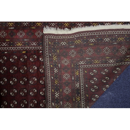 228 - A 20th century Turkomen rug with a lattice of guls on a madder red field within multiple borders. 19... 