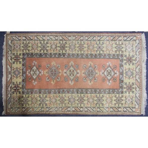 232 - A 20th century Turkish rug with diamond lozenges on a muted red ground within broad borders and frin... 