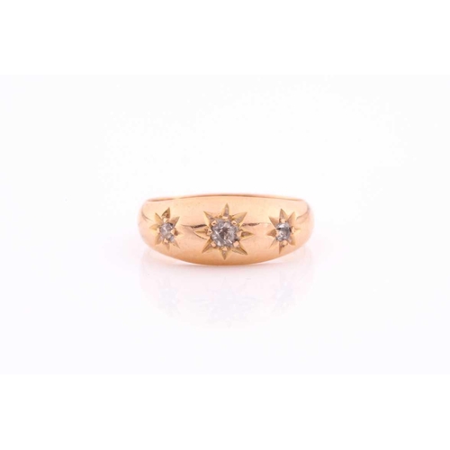 111 - A three stone gypsy set ring, the graduated old brilliant cut diamonds in tapering 18 carat rose gol... 