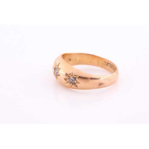 111 - A three stone gypsy set ring, the graduated old brilliant cut diamonds in tapering 18 carat rose gol... 