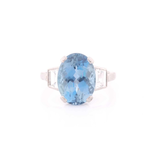 114 - A diamond and blue topaz ring, set with a mixed oval-cut topaz, measuring approximately 12 x 8.5 mm,... 