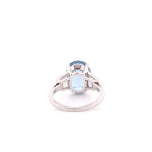 114 - A diamond and blue topaz ring, set with a mixed oval-cut topaz, measuring approximately 12 x 8.5 mm,... 