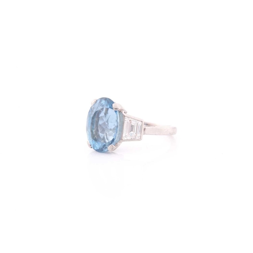 114 - A diamond and blue topaz ring, set with a mixed oval-cut topaz, measuring approximately 12 x 8.5 mm,... 