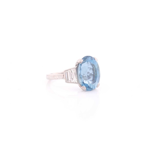 114 - A diamond and blue topaz ring, set with a mixed oval-cut topaz, measuring approximately 12 x 8.5 mm,... 