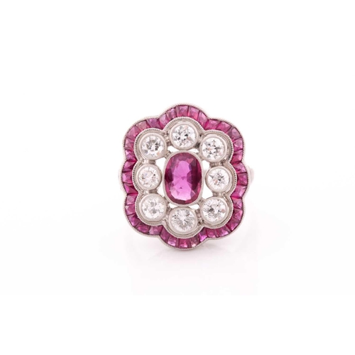 116 - A platinum, diamond, and ruby ring, the stylised mount centred with a mixed oval-cut ruby within a b... 