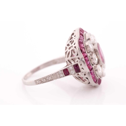 116 - A platinum, diamond, and ruby ring, the stylised mount centred with a mixed oval-cut ruby within a b... 