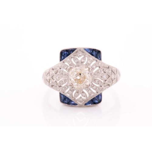 306 - An unusual diamond and sapphire ring, in the Art Deco style, centred with an old cushion-cut diamond... 