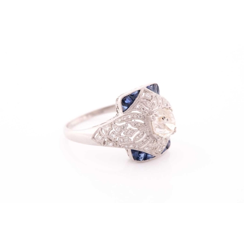 306 - An unusual diamond and sapphire ring, in the Art Deco style, centred with an old cushion-cut diamond... 