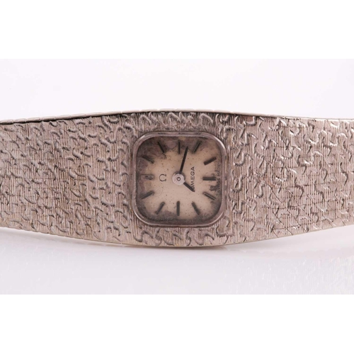 307 - An 18ct white gold ladies Omega cocktail watch, the small baton dial inset into an articulated strap... 