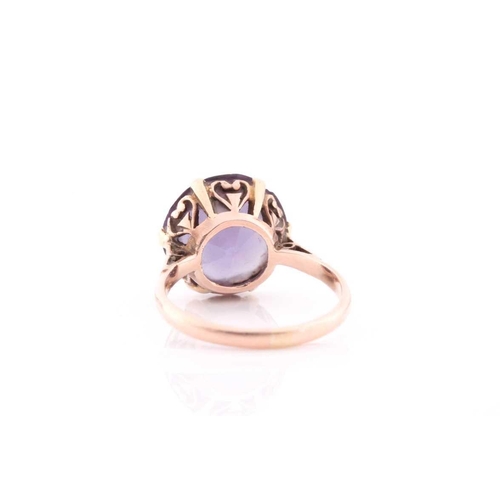 309 - A singe stone synthetic corundum dress ring; the circular cut stone in six claw moutnt above a heart... 