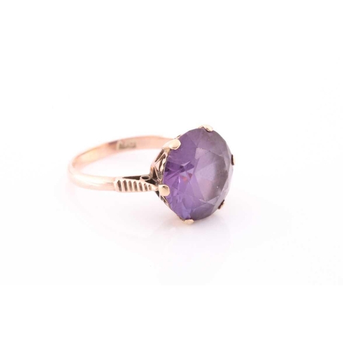 309 - A singe stone synthetic corundum dress ring; the circular cut stone in six claw moutnt above a heart... 