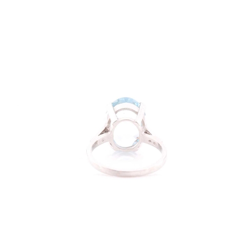 312 - A single stone aquamarine ring, the oval cut aquamarine in four claw mount above five stone eight-cu... 